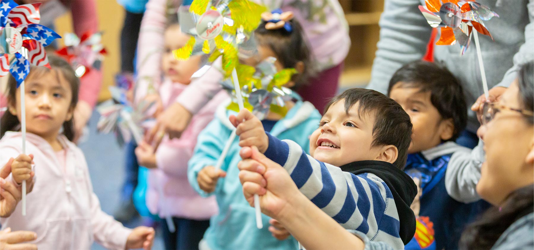 Children play with colorful pinwheels