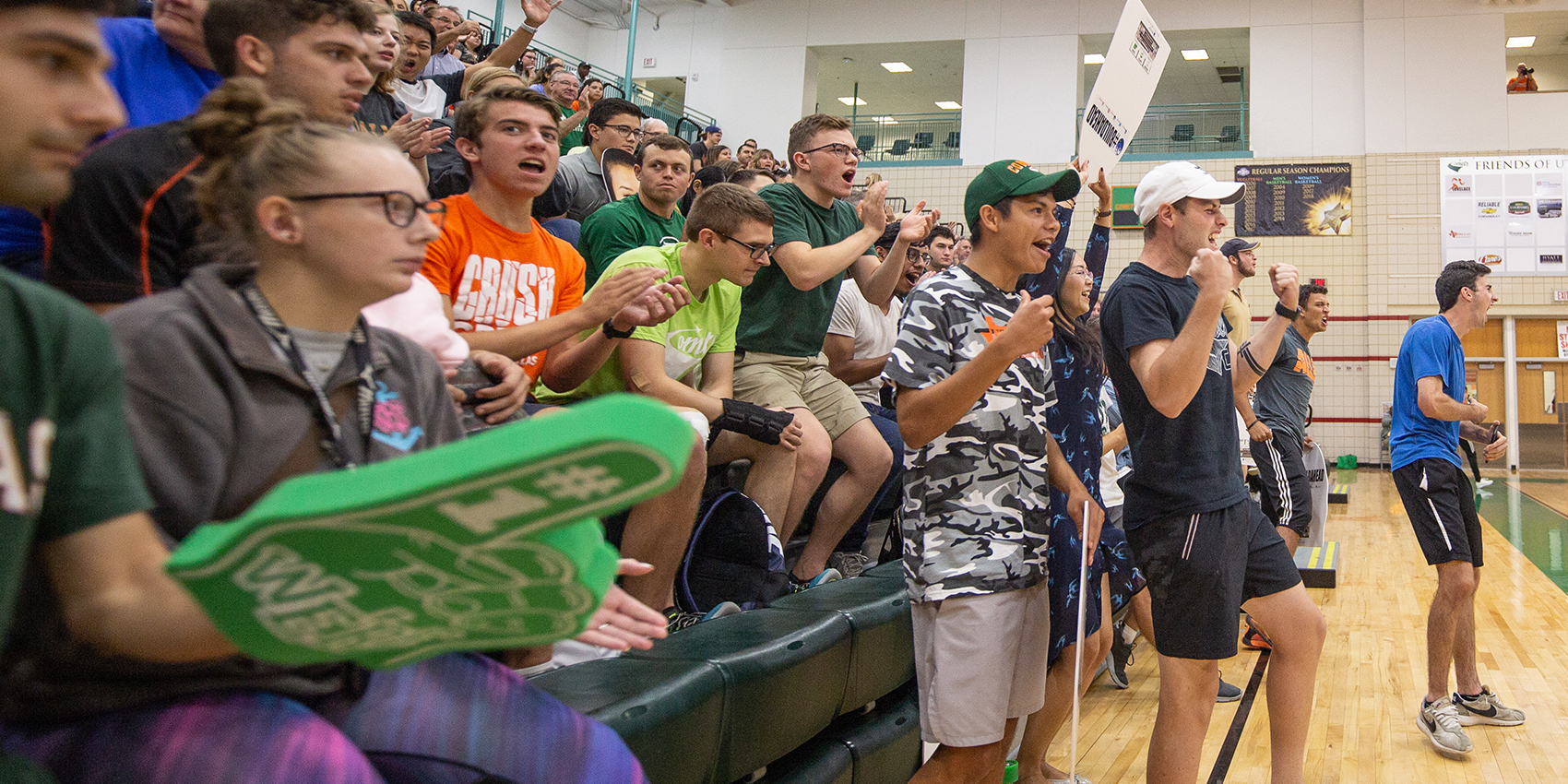 Students cheering on a team in a gymnasium